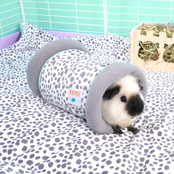 black and white guinea pig inside Kavee dalmatian print tunnel on dalmatian print fleece liner in white c&c cage with lilac coroplast and hay box in the background