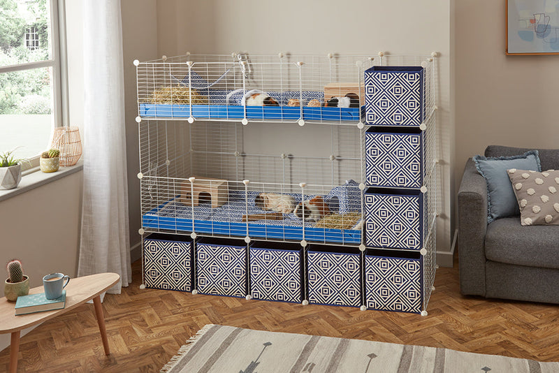 A two tier white 4x2 c&c cage with stand and side storage for guinea pigs with two levels black correx baby safe grids by brand kavee in the USA